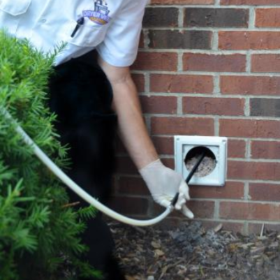 Technician cleaning vent outdoors.