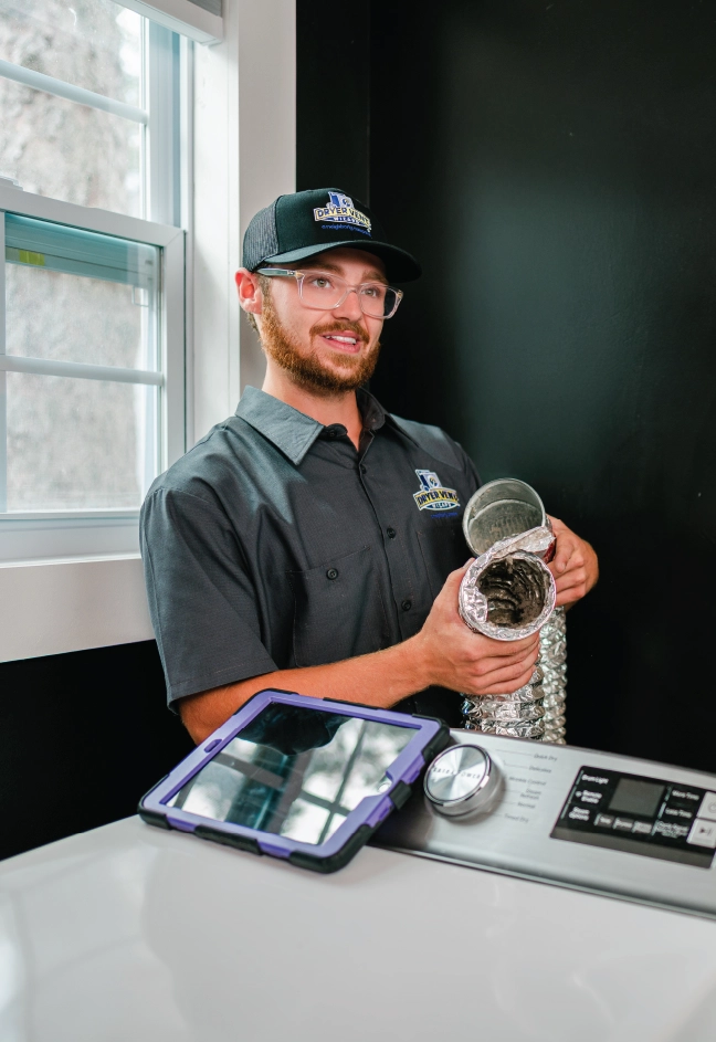 Dryer vent professional holding up a dirty dryer vent hose in laundry room and showing homeowner.