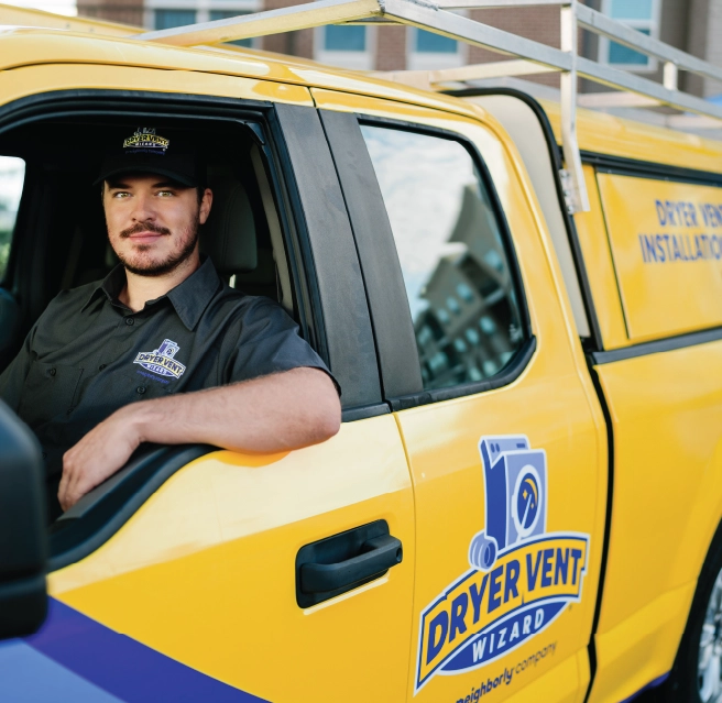 Two male dryer vent cleaners in company van smiling.