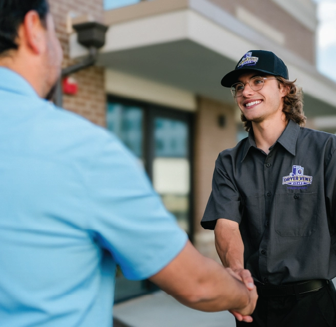 Homeowner and dryer vent cleaning professional shake hands outside of home.