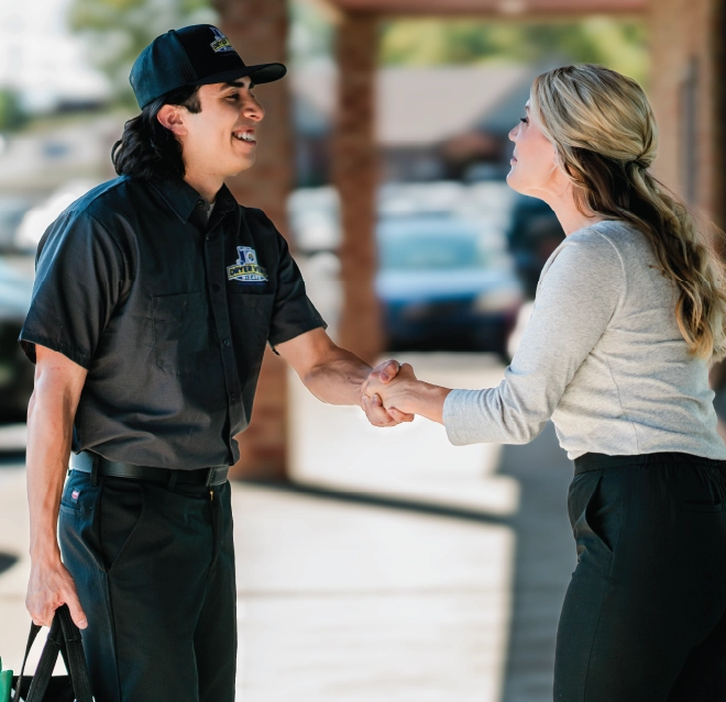 Female business owner speaks with dryer vent cleaner outside of building.