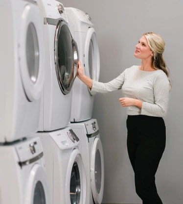 Woman admiring her clean, stacked commercial dryers.