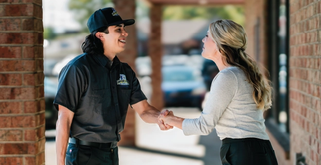 Male Dryer Vent Wizard professional shaking hands with a female commercial business.