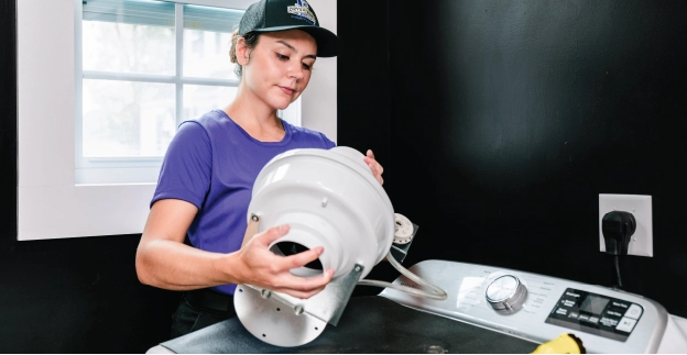 Female technician cleaning booster fan.