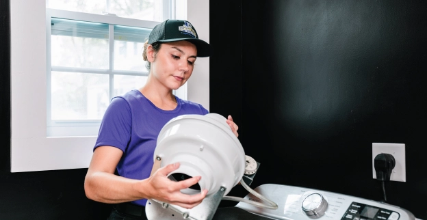 Female Dryer Vent Wizard professional fixing a residential dryer vent.