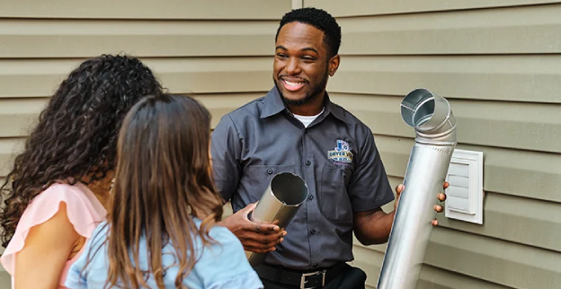 Dryer Vent Wizard technician outside explaining dryer vent installation to a family.