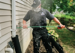 Dryer Vent Wizard professional standing outside of home cleaning dryer duct.