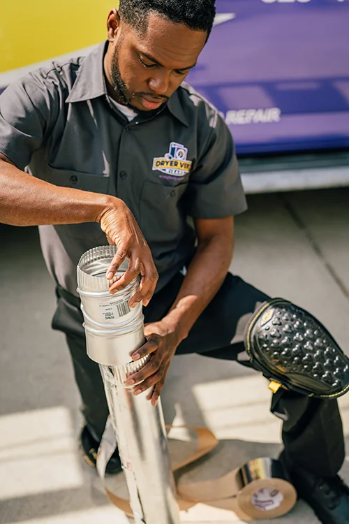 Dryer Vent Wizard technician completing a dryer vent repair outside