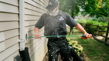 Professional using dryer vent cleaning tool.