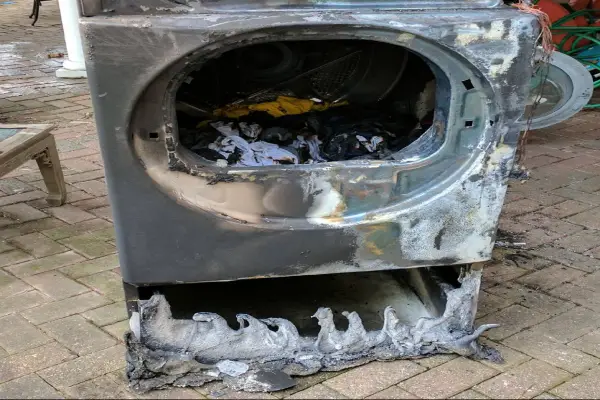 A picture of a burnt out dryer after catching on fire.