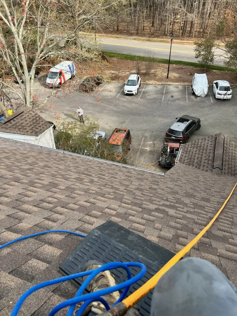 A Dryer Vent Wizard technician on a customer's roof cleaning out their dryer vent.