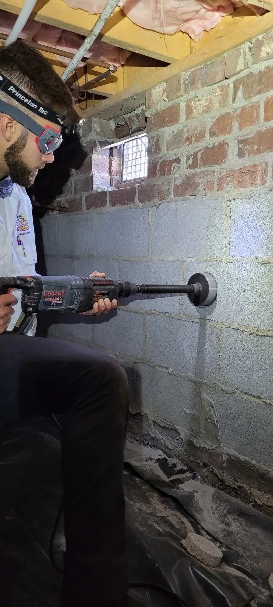 A Dryer Vent Wizard technician drilling into a customer's wall.