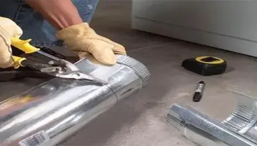 A Dryer Vent Wizard technician cutting a dryer vent.